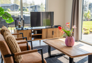 Bright living area in Villa Waterzicht Luxe 6 at Holiday park Molenvelden, Netherlands, featuring garden views.