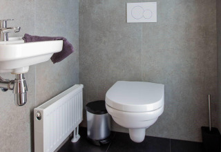 Modern bathroom in Villa Waterzicht Luxe 6 at Holiday park Molenvelden, Netherlands, with wall toilet.