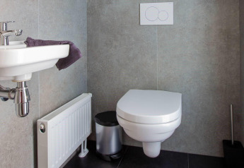 Moderne badeværelse på Villa Waterzicht Luxe 6, Holiday park Molenvelden, Nederlandene med væghængt toilet.