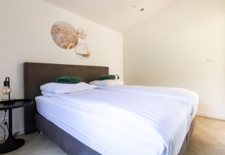 Camera moderna con letto matrimoniale presso Villa Waterzicht Luxe nel parco vacanze Molenvelden, Paesi Bassi.
