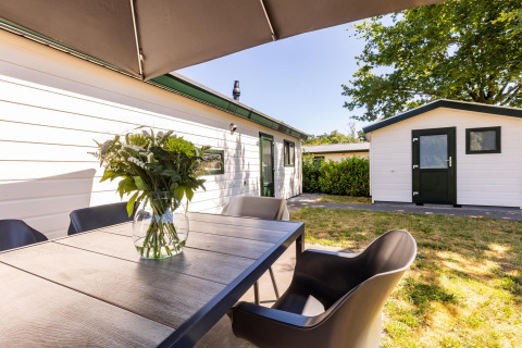 Außenbereich des White Lodge im Holiday park Molenvelden in den Niederlanden mit Tisch und Stühlen.