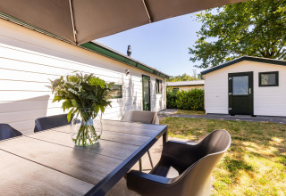 Espace repas extérieur à White Lodge au parc de vacances Molenvelden, Pays-Bas, avec vase et chaises modernes.