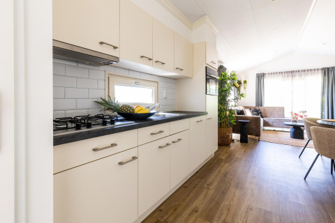 Cuisine moderne et salon à White Lodge, Holiday park Molenvelden, Pays-Bas, avec parquet en bois clair.