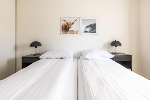 Dormitorio luminoso en White Lodge, Holiday park Molenvelden, Países Bajos, con camas gemelas y diseño minimalista.