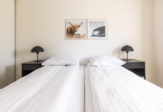 Bright bedroom at White Lodge, Holiday park Molenvelden, Netherlands, with twin beds and minimalist design.