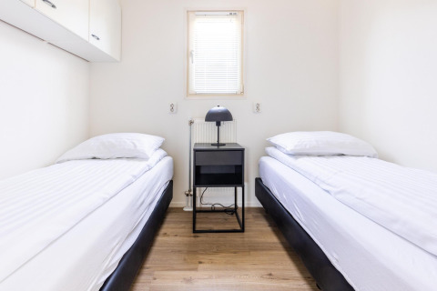 Moderne, minimalistisk soveværelse med to enkeltsenge på White Lodge, Holiday park Molenvelden, Holland.