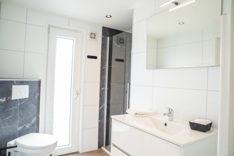 Baño moderno y luminoso en Wood Lodge Waterzicht, Holiday park Molenvelden, Países Bajos.