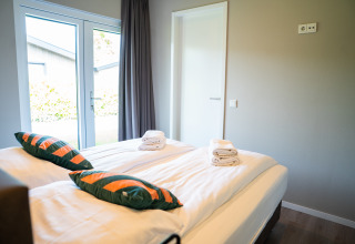 Moderne soveværelse i Wood Lodge Waterzicht, Holiday park Molenvelden, hollandsk indretning og lys.