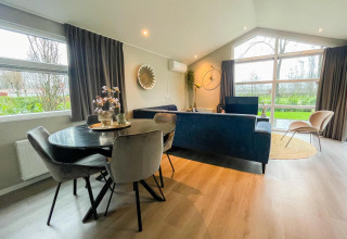 Gemütliches Wohnzimmer der Wood Lodge im Holiday Park Molenvelden, Niederlande, mit stilvoller Einrichtung.