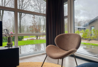 Innenansicht der Wood Lodge im Holiday Park Molenvelden, Niederlande, große Fenster bei Regenwetter.