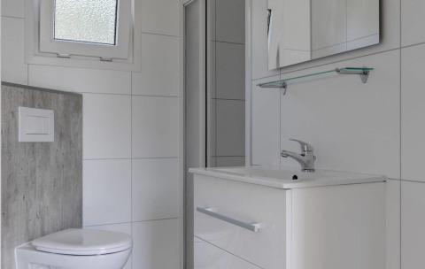 Bagno moderno con wc, lavandino e specchio al Wood Lodge presso Holiday park Molenvelden nei Paesi Bassi.