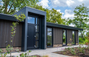 Lodge moderne à Villa Veldzicht, Holiday park Molenvelden aux Pays-Bas, entouré de nature et jardin paysager.