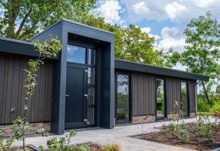 Moderne Lodge Villa Veldzicht im Ferienpark Molenvelden, Niederlande, mit naturreicher Umgebung und Garten.