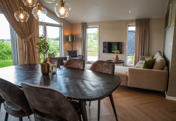 Modern eingerichtetes Wohnzimmer und Essbereich in Villa Veldzicht im Holiday Park Molenvelden, Niederlande.