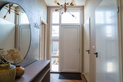 Indgang til Villa Veldzicht på Holiday park Molenvelden med moderne indretning og stort spejl.