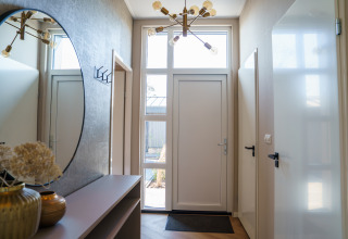 Entrada de Villa Veldzicht en Holiday park Molenvelden, Países Bajos, con decoración moderna y gran espejo.