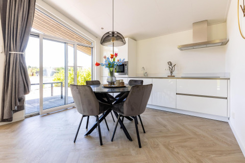 Zona pranzo e cucina luminosa e moderna nella Villa Waterzicht Luxe met Hottub 4, Holiday park Molenvelden, Paesi Bassi.