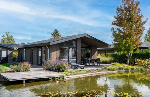 Luksuriøs villa med hottub ved søen, moderne trædesign og terrasse i ferieparken Molenvelden, Holland.