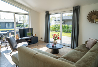 Helles, modernes Wohnzimmer in der Villa Waterzicht Luxe met Hottub 6 im Ferienpark Molenvelden, Niederlande.