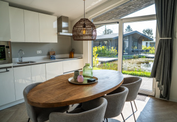 Moderne keuken en eetruimte met zicht op tuin en vijver in Villa Waterzicht Luxe met Hottub 6, Molenvelden.