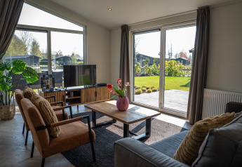 Salon moderne à la Villa Waterzicht Luxe avec jacuzzi au Holiday park Molenvelden, vue sur jardin.
