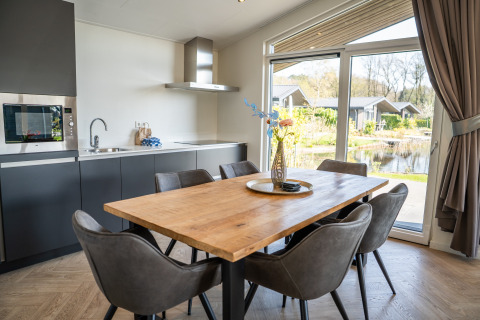 Zona pranzo moderna e cucina nella Villa Waterzicht Luxe con vasca idromassaggio al parco Molenvelden, Paesi Bassi.