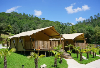 Canvas lodges bij Can Bora Lodges vakantiepark in Catalonië, Spanje, te midden van heuvels en palmen.