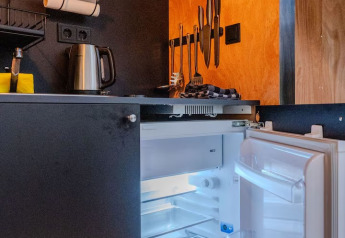 Cucinino moderno allo Slowlodge Echo di Zomerlicht, Paesi Bassi, con frigo aperto e utensili visibili.