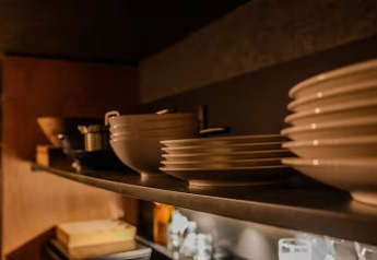 Piatti e ciotole di ceramica impilati su una mensola allo Slowlodge Echo a Zomerlicht, Paesi Bassi.