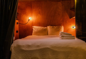 Camera accogliente in legno con luci soffuse nello Slowlodge Echo di Zomerlicht, Paesi Bassi.