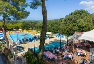 View of swimming pool and outdoor dining area at Sandaya Le Pianacce holiday park in sunny Tuscany, Italy.