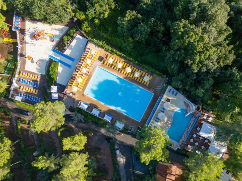 Luftfoto af Sandaya Le Pianacce feriepark i Toscana, Italien, med swimmingpools, solsenge og grøn natur.