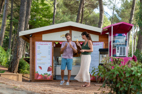 To personer nyder is foran en hyggelig bod i en skov ved Sandaya Le Pianacce, Toscana, Italien.