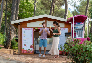 To personer nyder is foran en hyggelig bod i en skov ved Sandaya Le Pianacce, Toscana, Italien.