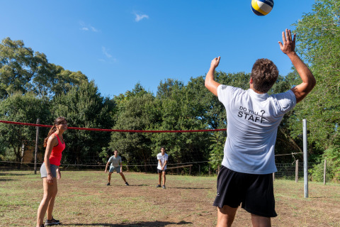 Gæster spiller volleyball udendørs på Sandaya Le Pianacce feriepark i Toscana, Italien, en solrig dag.