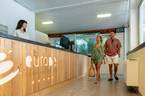 Par ankommer til receptionen på Sandaya Europa Village feriepark i Veneto, Italien og bliver budt velkommen.