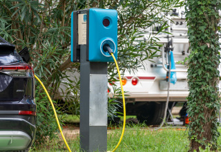 Voiture électrique en charge à une station au milieu de la verdure à Sandaya Europa Village, Vénétie, Italie.