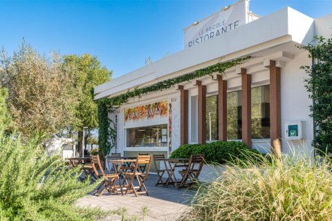 Außenterrasse mit Sitzplätzen am Le Bricole Ristorante im Sandaya Europa Village, Venetien, Italien.