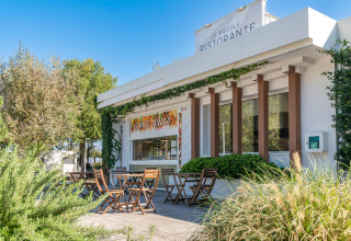 Buitenterras met houten tafels aan Le Bricole Ristorante in Sandaya Europa Village, Veneto, Italië.