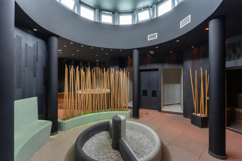 Modern spa area with circular seating, tall bamboo sticks, and zen accents at Sandaya Europa Village, Veneto.