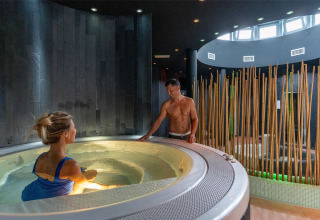 Due persone si rilassano nell'area benessere con vasca idromassaggio al Sandaya Europa Village in Veneto.