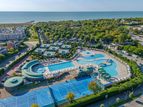 Vista aérea del parque vacacional Sandaya Europa Village en Véneto, Italia, con piscinas, canchas de tenis y mar.