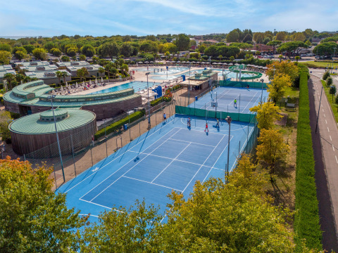 Feriepark i Veneto, Italien, med blå tennisbaner, swimmingpool og moderne faciliteter om sommeren.