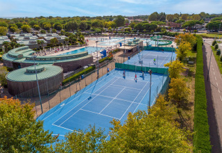 Feriepark i Veneto, Italien, med blå tennisbaner, swimmingpool og moderne faciliteter om sommeren.