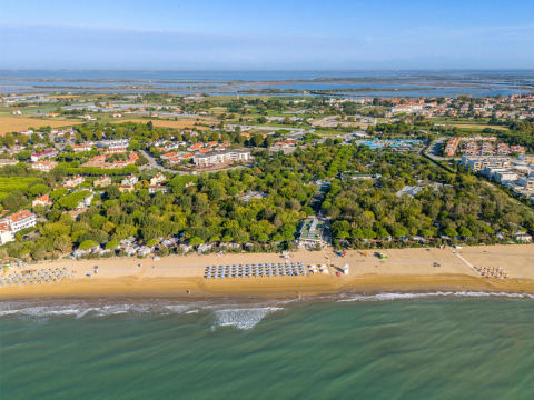 Aerial view of Sandaya Europa Village holiday park in Veneto, Italy showing the sandy beach and greenery.
