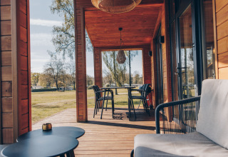 Gemütliche Holzveranda des Beach House in Wilsumer Berge, Deutschland, mit Möbeln und Naturblick