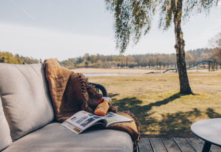 Gemütlicher Sitzbereich mit Decke, Sonnencreme und Magazin im The Beach House in Wilsumer Berge, Deutschland.