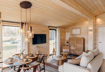 Lyst og moderne opholdsrum i The Beach House ved Wilsumer Berge, Tyskland, med træinteriør og hyggelig indretning.