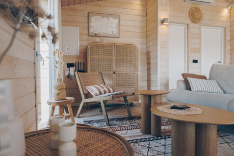 Salon chaleureux du Beach House à Wilsumer Berge, Allemagne, avec des meubles en bois et rotin.