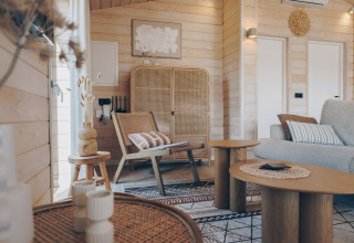 Salon chaleureux du Beach House à Wilsumer Berge, Allemagne, avec des meubles en bois et rotin.